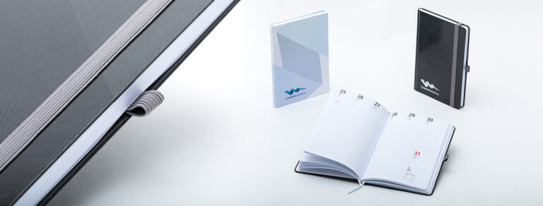 Verschiedene Notizbücher mit Hardcover, aufgeschlagen oder geschlossen stehend.