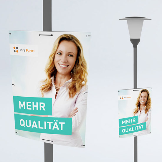 An zwei Straßenlaternen angebrachte Hohlkammperplakete mit dem Abbild einer lächelnden Frau und dem Text "Mehr Qualität".