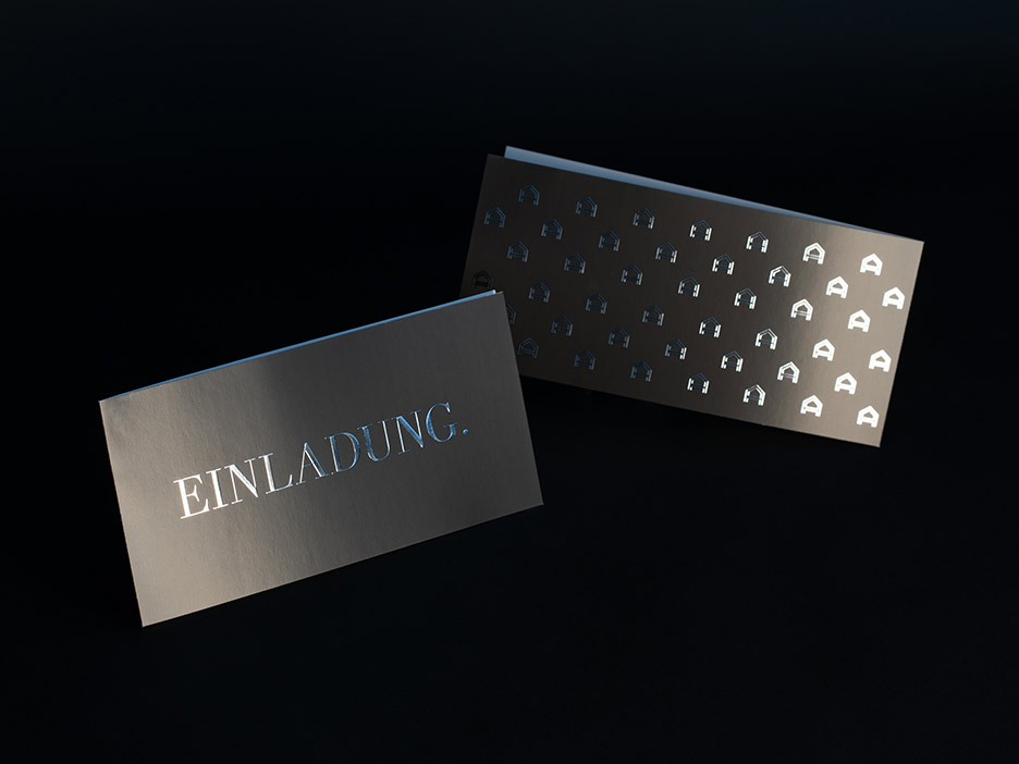 Im Vordergrund die Titelseite und im Hintergrund die Rückseite einer Grußkarte im Querformat mit Silberfolie veredelten Buchstaben