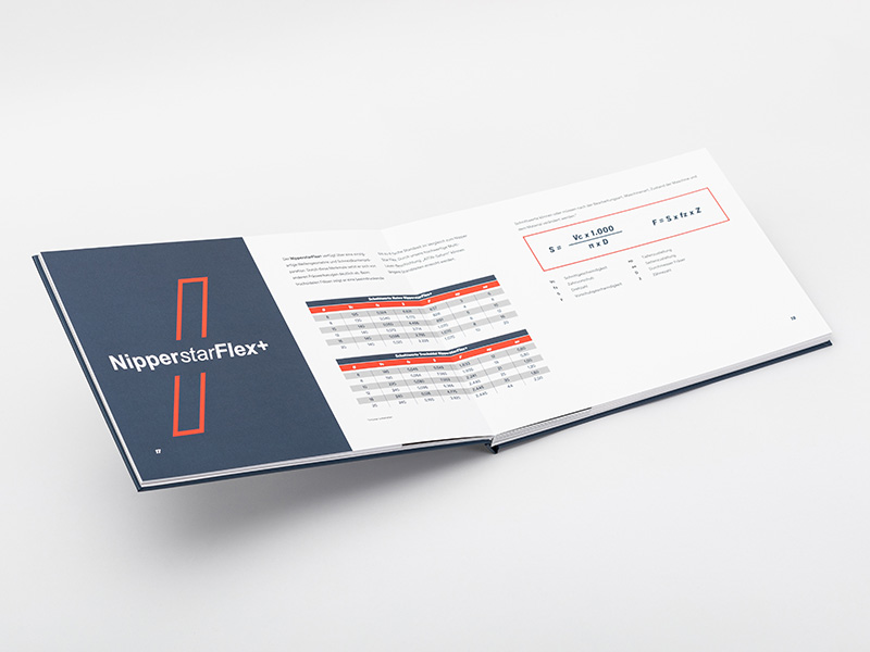 Ein plan aufliegendes Layflat-Hardcover mit seitenübergreifender Tabellendarstellung.