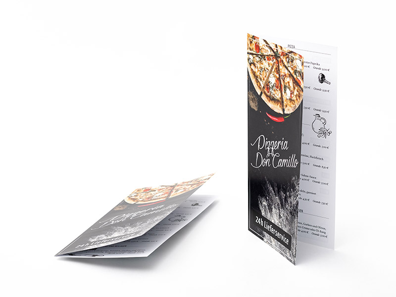 Ein liegender und ein aufgestellter Flyer, der in der Mitte gefalzt ist
