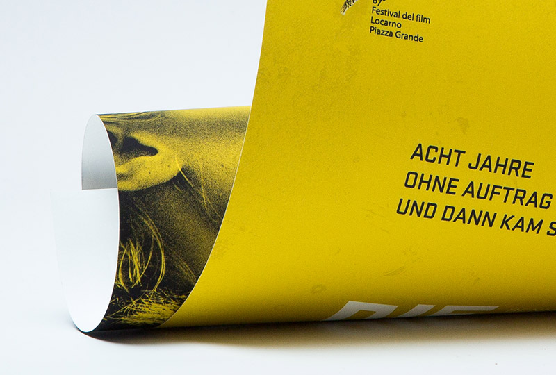 Ein leicht abgerolltes Plakatmotiv in schwarz-gelb.