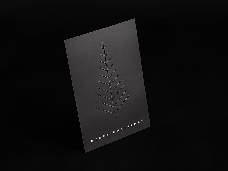 Eine schwarze Postkarte mit haptisch erhabener partieller Veredelung von kleinen Icons in Form von Häusern auf der Vorderseite.
