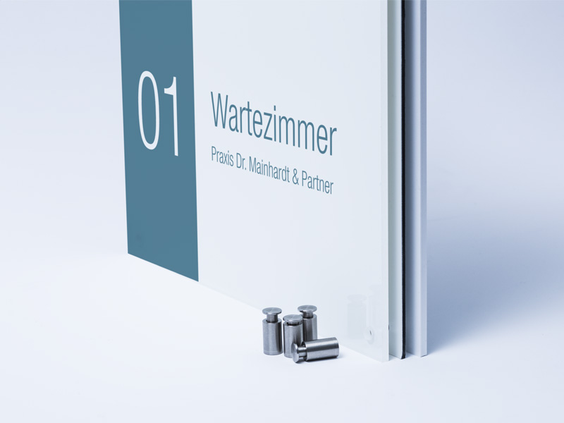 Die Abbildung zeigt zwei Schilder die parallel zueinander im Anschnitt dargetsellt sind und vor denen vier silberfarbene Aufhängungen stehen.