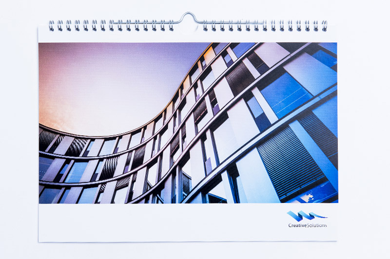 Die Abbildung zeigt einen Wandkalender im DIN A3 Querformat mit glänzendem UV-Lack auf der Vorderseite.